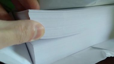 Ofis çalışanı boş kağıtları karıştırıyor. İş kağıdı kavramı