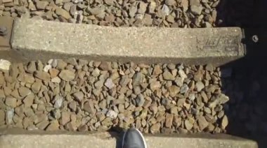 Demiryolunda ilerleyen bir adamın akıllı telefonunun videosu. Yaz yürüyüşü kavramı