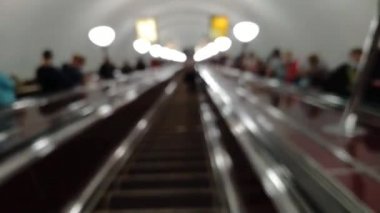 Metroda yürüyen merdivenden inen bir adamın hızlandırılmış videosu.