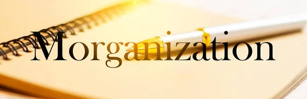 Morganization - word on the background of a business pen with a notepad in the office