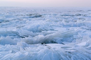 Donmuş bir su kütlesinin üzerinde beyaz karla kaplı bir sürü buz parçası. Doğu Avrupa 'da kış. Manzara. Yatay yönelim.