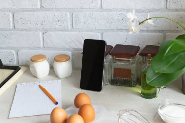 Çevrimiçi yemek kursları. Akıllı telefon ev mutfağında, ürünlerin arasında. Yemek pişirme dersi. Boşluğu kopyala.