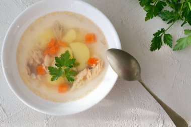 Sebzeli balık çorbası ve beyaz tabakta yemek kaşığı olan beyaz bir kasede somon balığı. Sağlıklı beslenme konsepti. Üst Manzara. Yatay yönelim. 