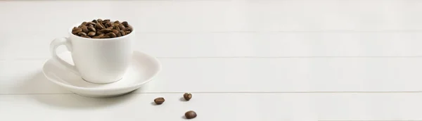 Banner Coffee beans in a white espresso cup with several beans on a white background. Morning coffee concept.