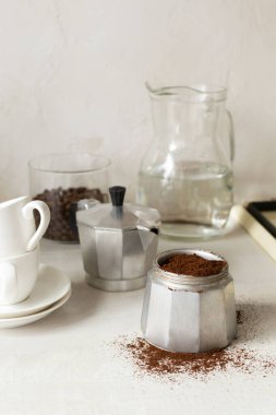 Evde kahve yapma sürecini. Ev mutfağındaki gayzer kahve makinesine kahve dökülüyor. Dikey yönelim. 