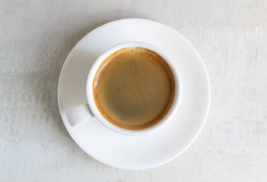 Beyaz fincan ve çay tabağında mis kokulu espresso. Sabah geleneği. Ev kahvesi yapma konsepti. Yatay oryantasyon. Üst görünüm. 