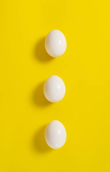 Three White Chicken Eggs Lie Yellow Background Vertical Orientation Top — Stock Photo, Image