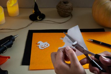 Adım adım talimat veriyorum. Cadılar Bayramı için keçeli bir çelenk yapıyorum. Süpürge sapı üzerindeki balkabağını ve cadıyı kes..