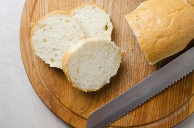 Fransız soğan çorbası pişirme süreci. Tahta bir kesme tahtasının üzerinde baget dilimleri halinde kesilmiş. Geleneksel mutfak konsepti. Yatay oryantasyon. Seçici odak.