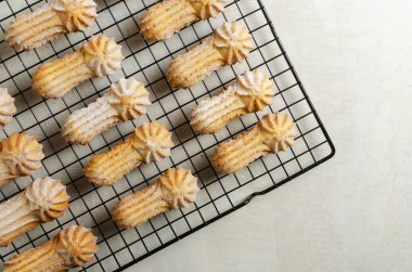 Gri arka planda uzun çubuk kurabiyeler, güzel kenarlar ve pudra şekeri. Çay ya da kahve zamanı konsepti. Seçici odaklanma. Üst Manzara. Yatay oryantasyon. Boşluğu kopyala