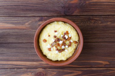 Klasik banosh, bryndza ve pastırma dilimleri ile dekoratif seramik kasede ahşap bir masada. Geleneksel Ukrayna yemeği mısır unundan yapılır. Geleneksel mutfak konsepti. Seçici odaklanma. Üst görünüm