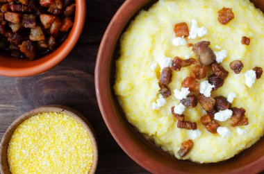 Klasik banosh, bryndza ve pastırma dilimleri ile dekoratif seramik kasede ahşap bir masada. Geleneksel Ukrayna yemeği mısır unundan yapılır. Geleneksel mutfak konsepti. Seçici odaklanma. Üst görünüm