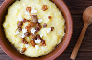 Klasik banosh, bryndza ve pastırma dilimleri ile dekoratif seramik kasede ahşap bir masada. Geleneksel Ukrayna yemeği mısır unundan yapılır. Geleneksel mutfak konsepti. Seçici odaklanma. Üst görünüm