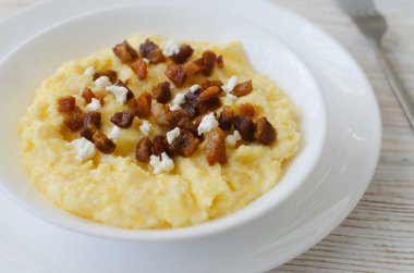 Otantik Hutsul banosh bryndza ve çatırtıları basit bir şekilde servis edilir. Geleneksel Ukrayna Karpatları yemeği konukseverliği, kültürü ve ev yemeklerini sembolize eder..