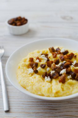 Otantik Hutsul banosh bryndza ve çatırtıları basit bir şekilde servis edilir. Geleneksel Ukrayna Karpatları yemeği konukseverliği, kültürü ve ev yemeklerini sembolize eder..