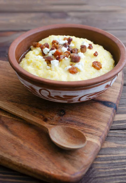 Klasik banosh, bryndza ve pastırma dilimleri ile dekoratif seramik kasede ahşap bir masada. Geleneksel Ukrayna yemeği mısır unundan yapılır. Geleneksel mutfak konsepti. Seçici odaklanma. Boşluğu kopyala