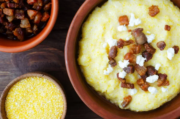 Klasik banosh, bryndza ve pastırma dilimleri ile dekoratif seramik kasede ahşap bir masada. Geleneksel Ukrayna yemeği mısır unundan yapılır. Geleneksel mutfak konsepti. Seçici odaklanma. Üst görünüm