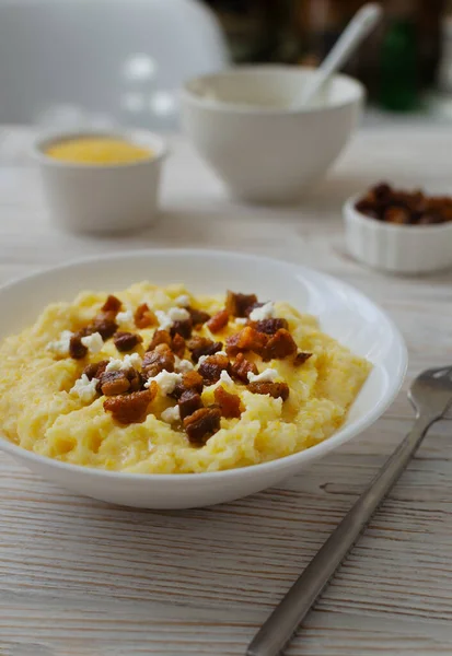 Geleneksel Hutsul banosh, bryndza ve ahşap bir masada beyaz bir kase içinde çıtır çıtır çıtır çıtır. Otantik Ukrayna mutfağı sıcak ve sade bir havası var. Seçici odak.
