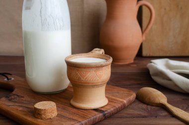 Geleneksel kil bardakla taze kefir, cam bir kavanozun yanına tıpa ile kapatılmış. Kültürel miras, zanaatkar gıda uygulamaları ve doğal yaşam tarzı. Mayalanmış süt ürünleri kavramları