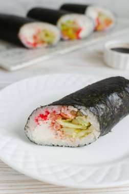 Pirinç, deniz ürünü, marul, krem peynir ve tobiko ile doldurulmuş dört suşi burrito. Suşi geleneklerini burrito tarzıyla birleştiren bir eritme yiyecek konsepti. Seçici odak