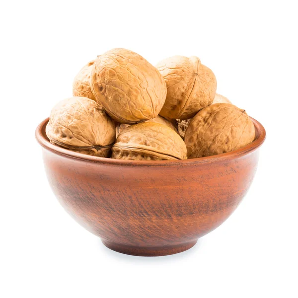 Las nueces en el plato de barro - aislado sobre el fondo blanco —  Fotos de Stock