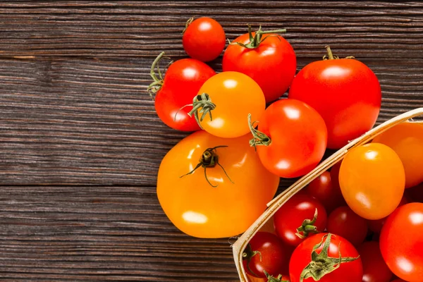Koyu ahşap yüzey üzerinde taze domates çeşitleri