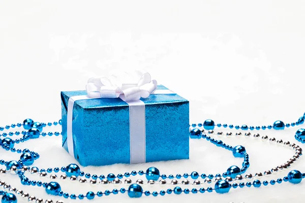 Parlak gümüş şerit ve beyaz zemin üzerine boncuk mavi Noel hediye kutusu