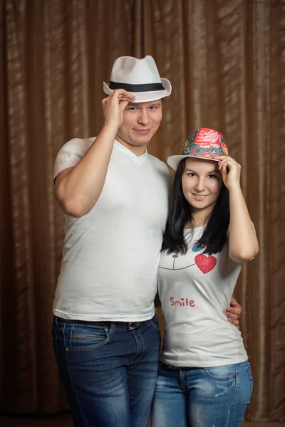 Chico con una chica aferrándose a sombreros — Foto de Stock