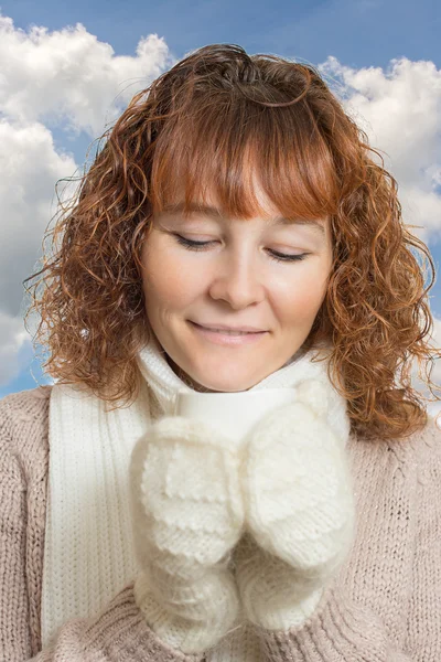 woman in mittens holding a cup