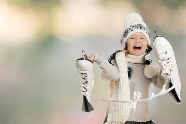 Маленькая девочка держит коньки и радуется — стоковое фото
