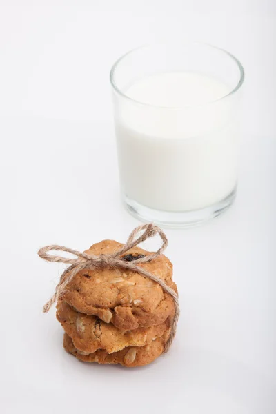 Galletas de grano entero y leche fresca sobre fondo blanco . — Foto de Stock