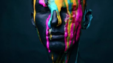 Renkli yüzü sarıya boyanmış genç bir adamın portresi.