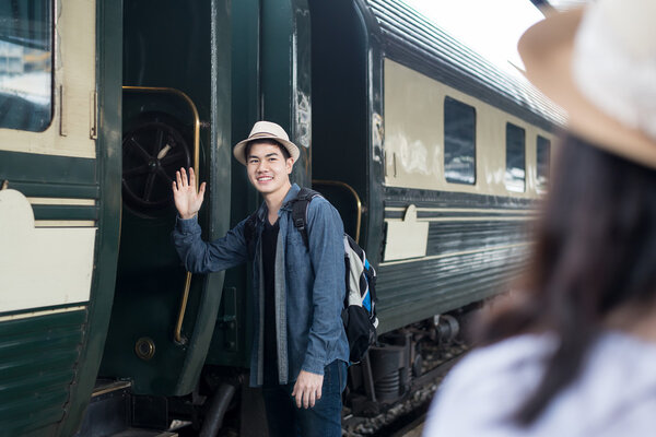 Handsome Young Asian man say goodbye to girlfriend at train stat