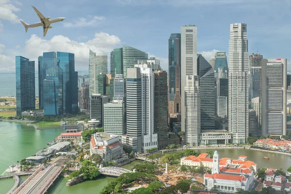 Avión volando sobre Singapur distrito de negocios por la mañana — Foto de Stock