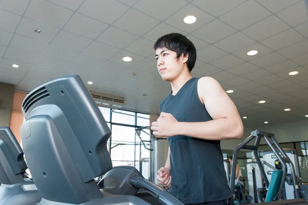 Азиатский юноша бегает по беговой дорожке в спортзале — стоковое фото