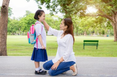 Okula dönüş. Okuldaki çocuklar öğrenci ile mutlu Asya anne. 