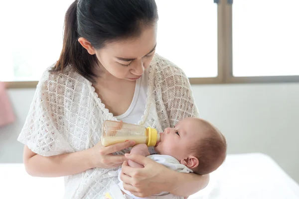 Кормление младенца. Азиатская мать кормит молоком своего новорожденного ребенка — стоковое фото