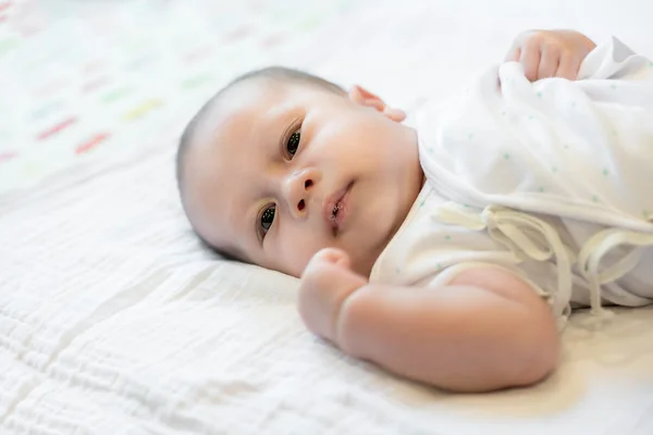 Asian 2 month baby with saliva newborn baby lying on belly in be — Stock Photo, Image