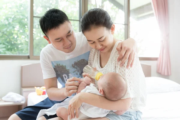 Кормление младенца. Азиатская семья с матерью и отцом кормятся — стоковое фото