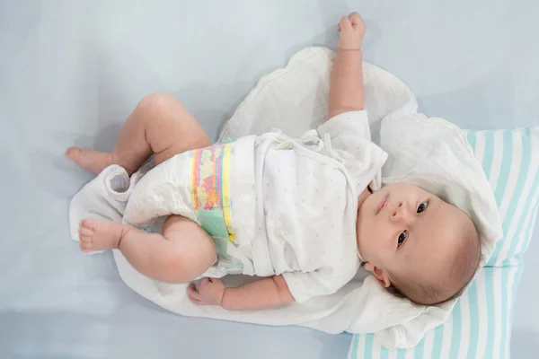 Portrait of a cute 2 months baby lying down on a bed, new family — Stock Photo, Image