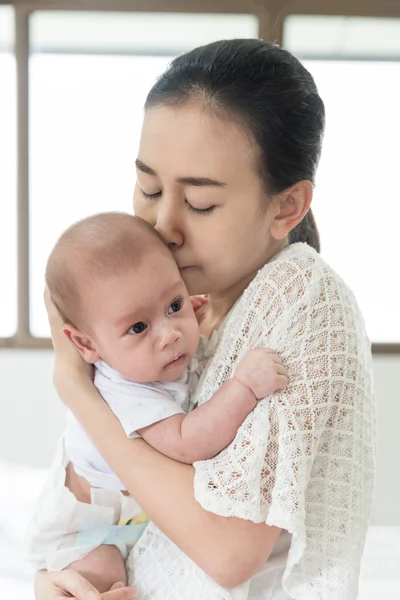 Imagen de la madre asiática feliz beso bebé niño después de llorar. Cl — Foto de Stock