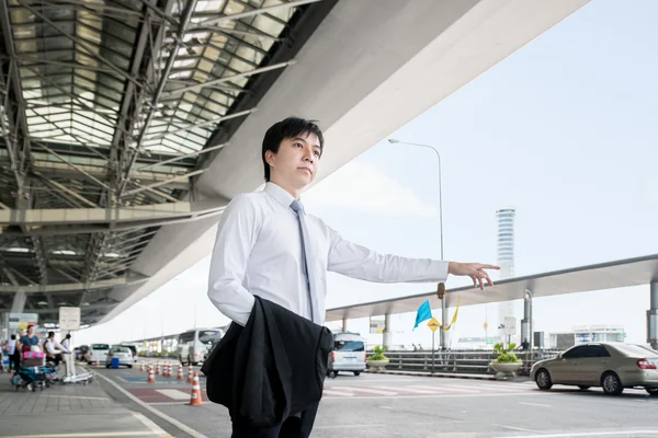 Concepto de viaje de negocios - Joven hombre de negocios asiático llamando taxi — Foto de Stock