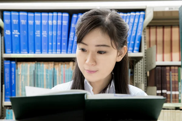 Asyalı lise öğrencisi üniversitede kütüphanede okuyor. Bir — Stok fotoğraf