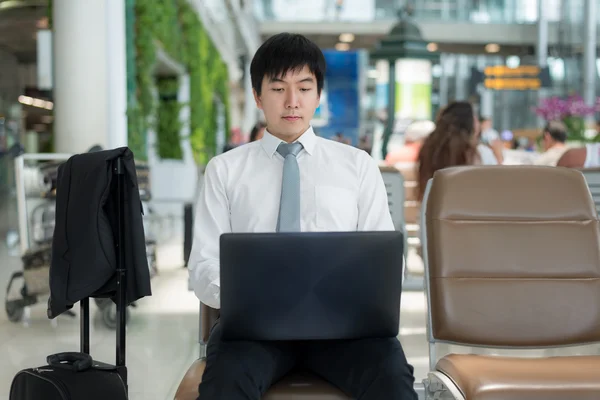 空港lでラップトップコンピュータを使用してアジアの若いビジネス旅行者 — ストック写真