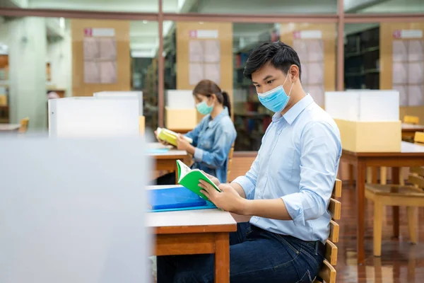 Zwei Asiatische Universitätsstudenten Tragen Mundschutz Und Sitzen Der Bibliothek Sozialem — Stockfoto