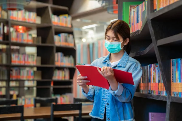 Asiatisches Studentenmädchen Mit Medizinischer Gesichtsschutzmaske Zum Schutz Vor Viruserkrankungen Liest — Stockfoto