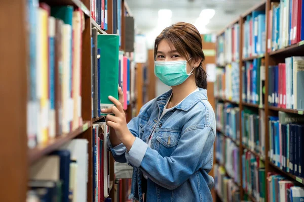 Asiatisches Studentenmädchen Mit Medizinischer Gesichtsschutzmaske Zum Schutz Vor Viruserkrankungen Liest — Stockfoto