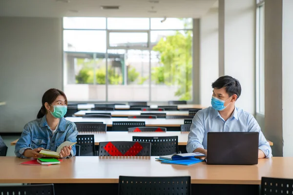 Zwei Asiatische Universitätsstudenten Tragen Mundschutz Und Sitzen Der Bibliothek Sozialem — Stockfoto