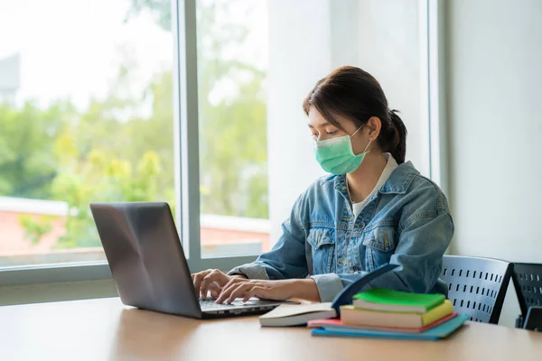 Asiatisches Studentenmädchen Mit Medizinischer Gesichtsschutzmaske Zum Schutz Vor Viruserkrankungen Arbeitet — Stockfoto