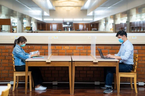 Два Азиатских Студента Маске Лица Сидя Библиотеке Расстоянии Социальной Других — стоковое фото